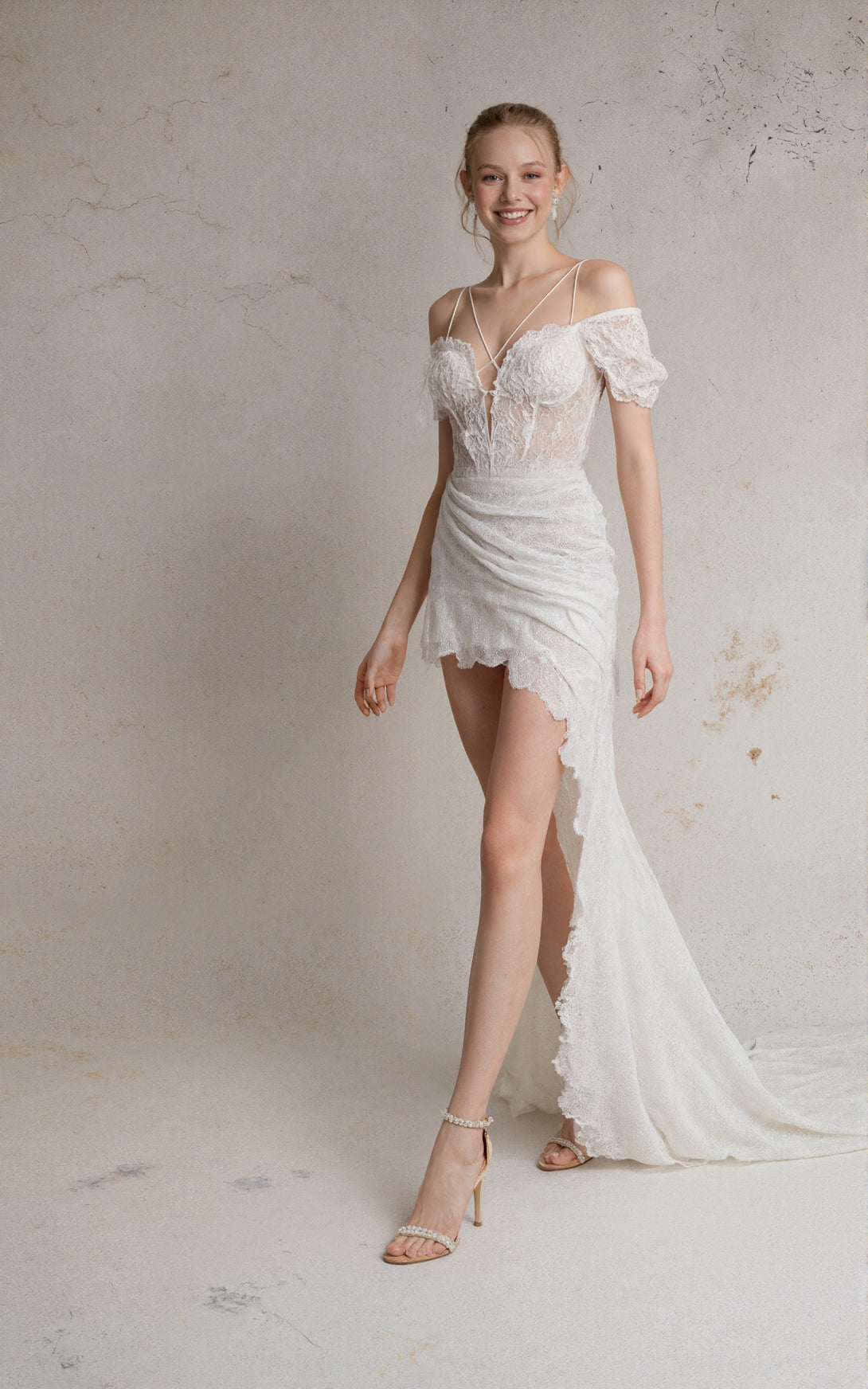 Woman wearing a white lace wedding dress against a neutral background